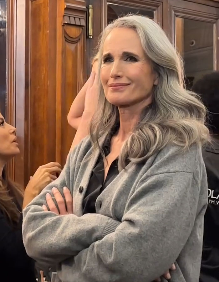 A woman with long gray hair and a gray cardigan smiling, related to Margaret Qualley's reverse nepotism discussion.