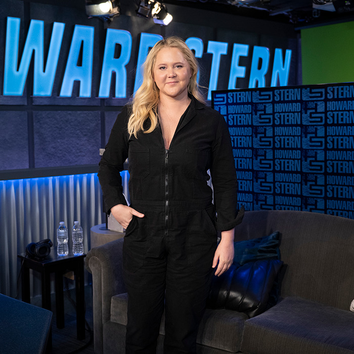 Amy Schumer in a black outfit, standing in a studio while discussing her Ozempic experience.