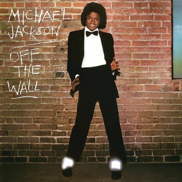 '70s song cover features artist in a tuxedo against a brick wall, highlighting timeless music influence.