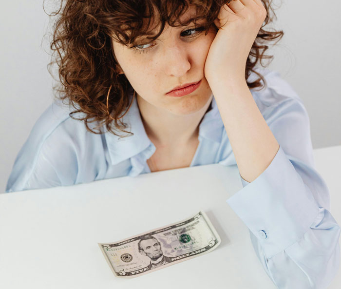 Babysitter looking disappointed with a five-dollar bill on the table.