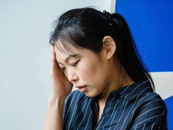 Babysitter in a striped shirt feeling stressed, agreeing to do more than promised with less pay.