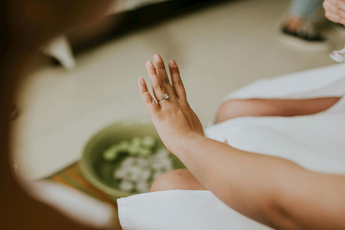 A woman with an engagement ring enjoys a relaxing bachelorette mini-vacation spa day.