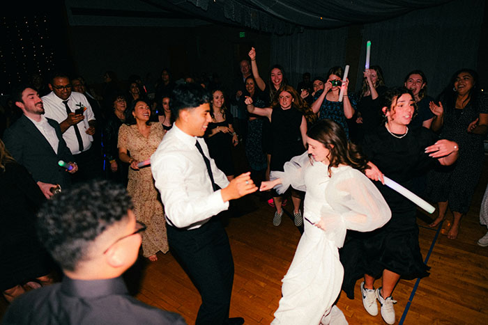 Bride dancing with guests at a lively wedding reception.