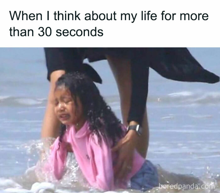 Child in pink shirt crying on the beach, humorously portraying an introvert's overwhelmed reaction to deep thoughts.