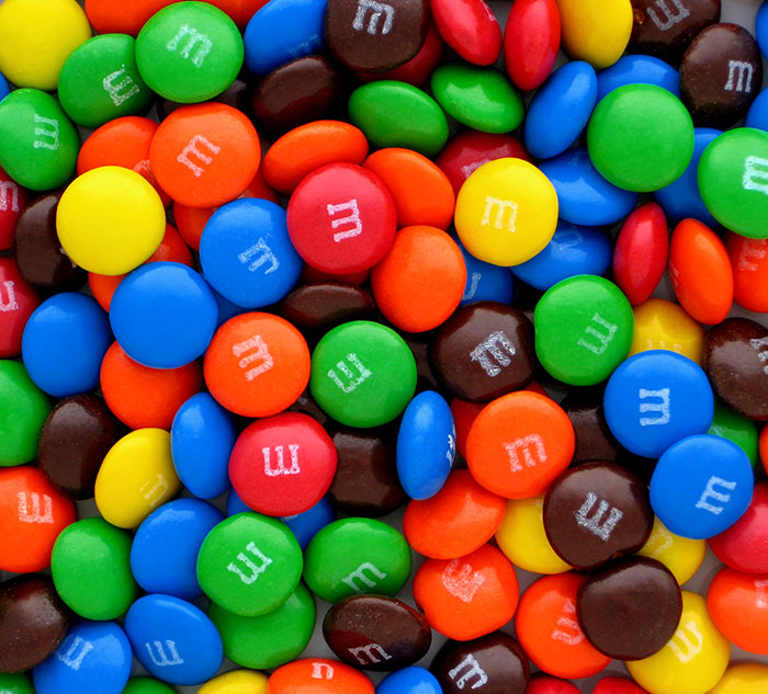 Colorful M&M candies scattered randomly, highlighting vibrant hues and textures.