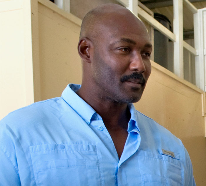 Man in a blue shirt standing indoors, related to celebrity secrets and scandals discussion.