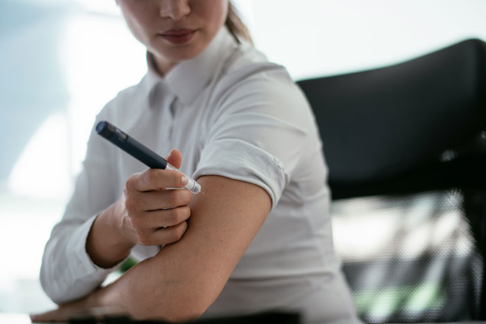 Person administering an injection in an office setting, highlighting health-related scams in America.