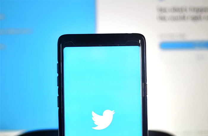 Phone displaying Twitter logo, symbolizing wasted money in history.