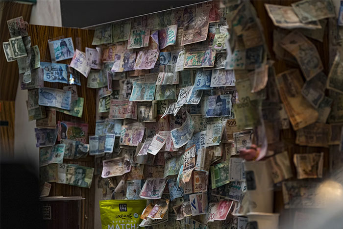 Banknotes displayed on a wall, illustrating instances of money being wasted in history.