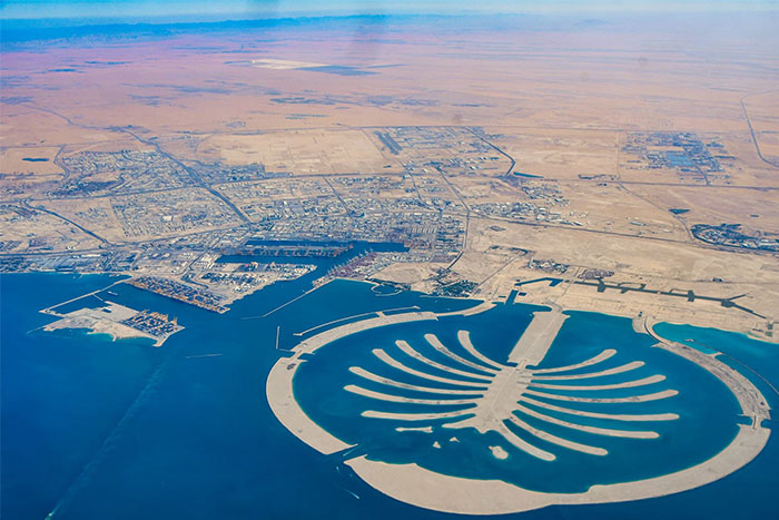 Aerial view of artificial island resembling a palm tree, symbolizing collective madness and wasted money in history.