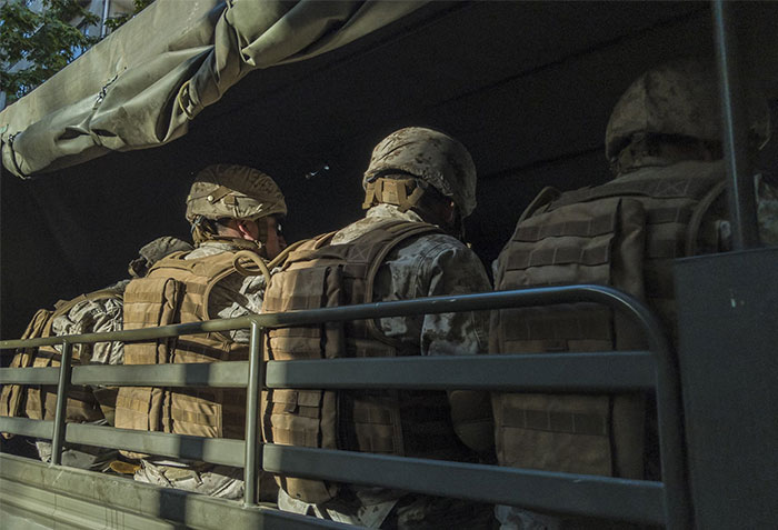 Soldiers in a military vehicle, illustrating instances of money being wasted in history.