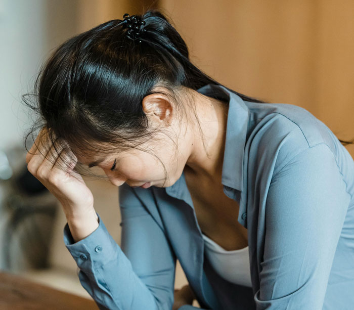 A woman in a blue shirt appears distressed during a wedding dress shopping trip.