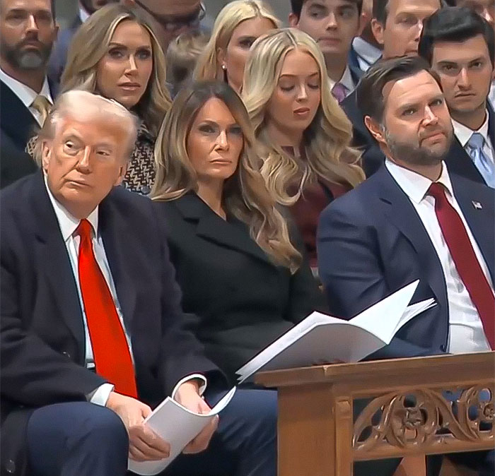 A group of people seated in a formal setting, holding programs, during a public event related to Bishop Mariann Budde's sermon.