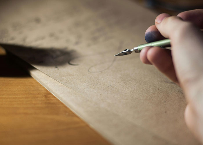 A person writing with a calligraphy pen, symbolizing unsolved mysteries from different countries.