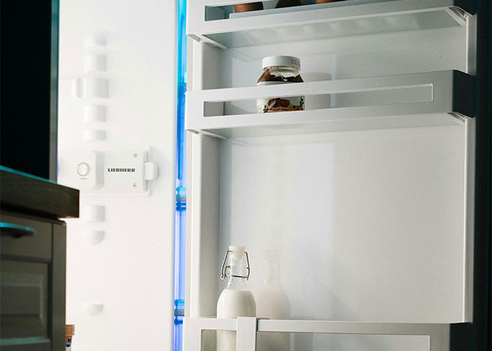 Open fridge with milk and a jar on shelves, related to unsolved mysteries.