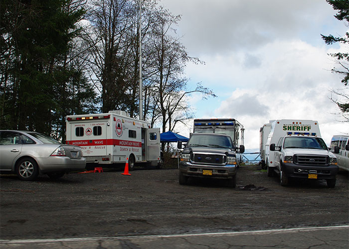 Rescue and sheriff vehicles at a mystery scene in a rural area, illustrating unsolved mysteries.