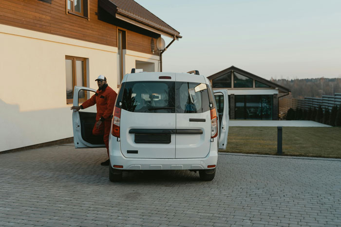 White van parked in driveway with person in red outfit exiting, related to black driveway van revenge theme.