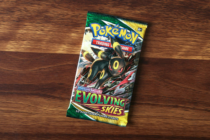 A pack of \"Evolving Skies\" Pokémon cards gifted for Christmas on a wooden table.