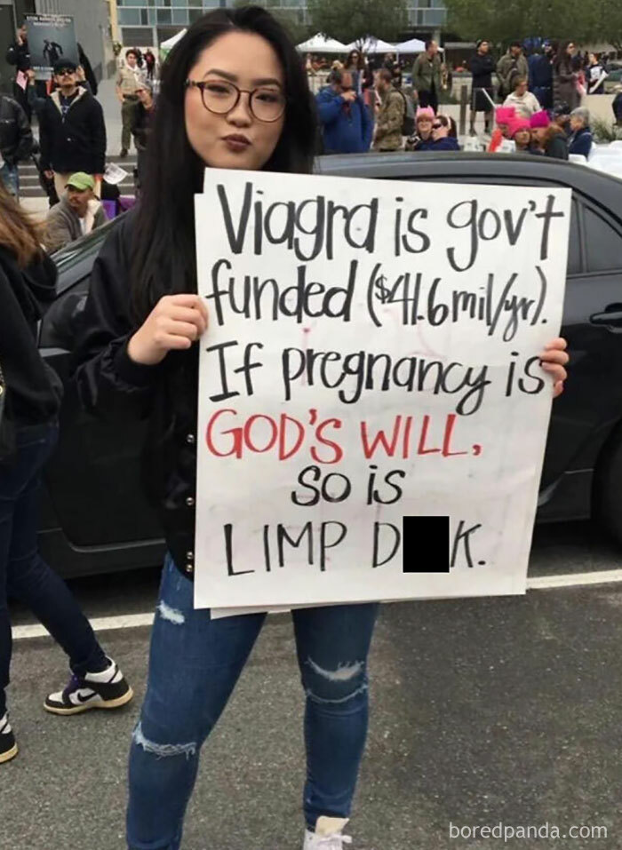 Person holding a humorous protest sign about government funding, showcasing bizarre brand new sentences.