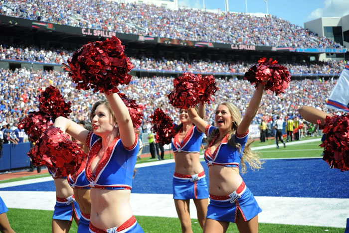 Cheerleaders in blue and red uniforms performing at a football game, representing Buffalo Bills cheerleader rules.