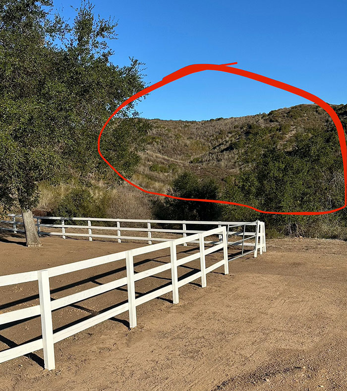 Dry brush and hills with red circle indicating wildfire risk area in LA.