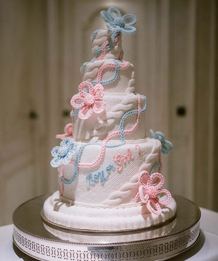 Tiered cake with pink and blue decorations, featuring "Boy or Girl?" text, related to $59 million wedding announcement.