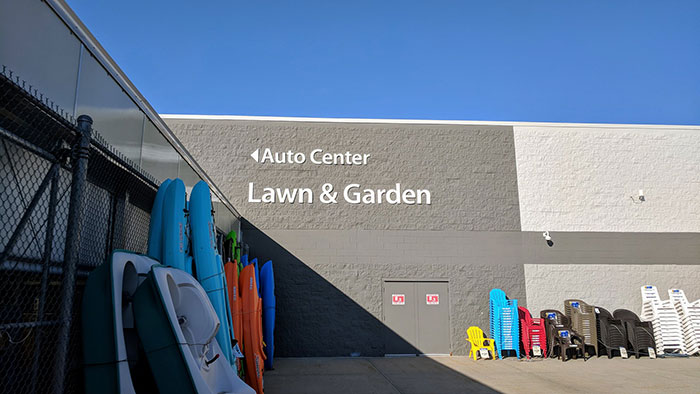 Lawn and Garden section of a retail store with stacked chairs and garden equipment.