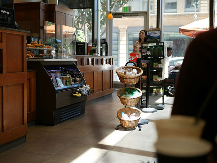 Retail scene with display baskets, counter, and a worker at the entrance, creating an authentic shopping atmosphere.