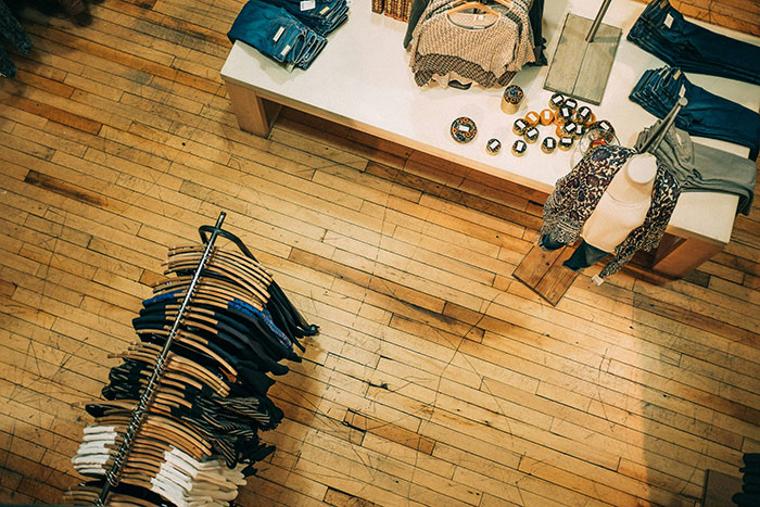 Retail store interior with folded clothes on a table and hanging items, showcasing a unique retail work environment.