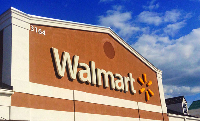 Walmart store exterior sign under a blue sky, showcasing a retail environment.