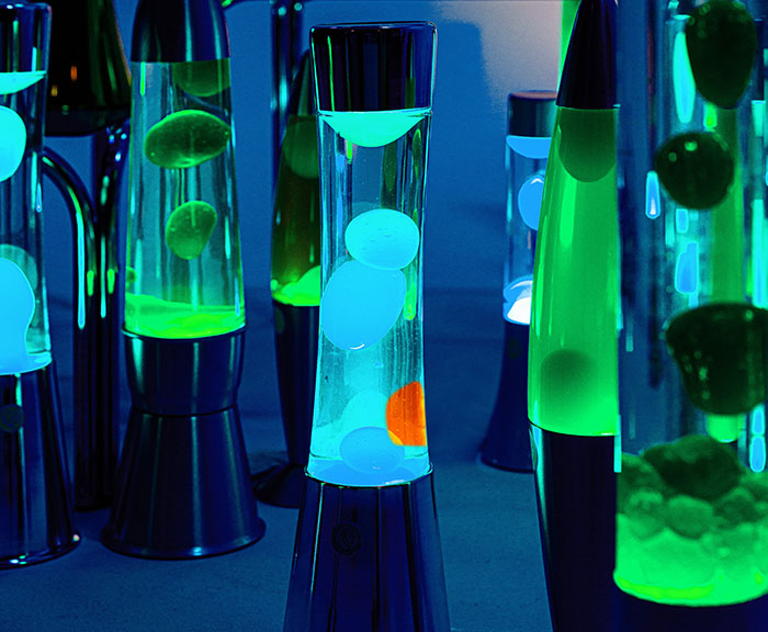 Glowing lava lamps in a dark room, showcasing vibrant colors and unique shapes.