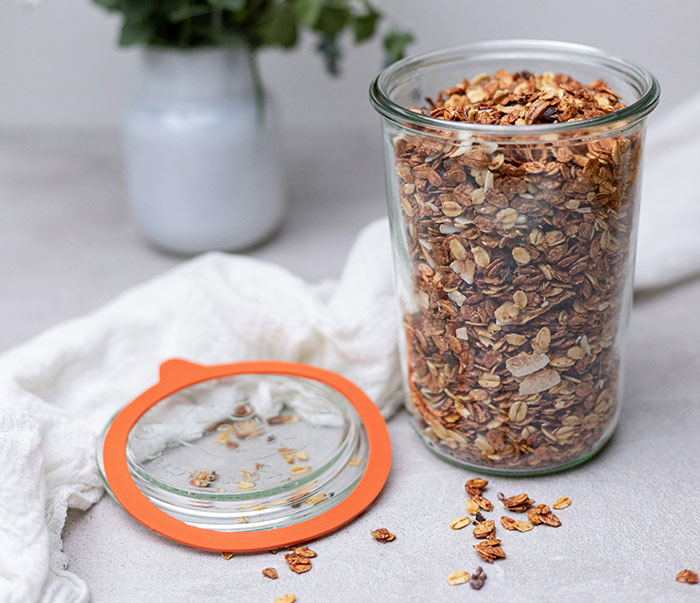 Jar of granola on a table, with a lid beside it, highlighting retail workers' surprising stories.