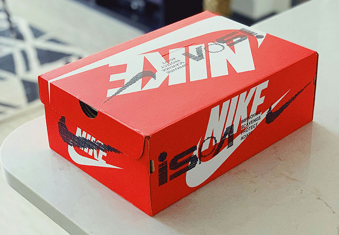 Red Nike shoe box on a white countertop, related to retail worker stories.