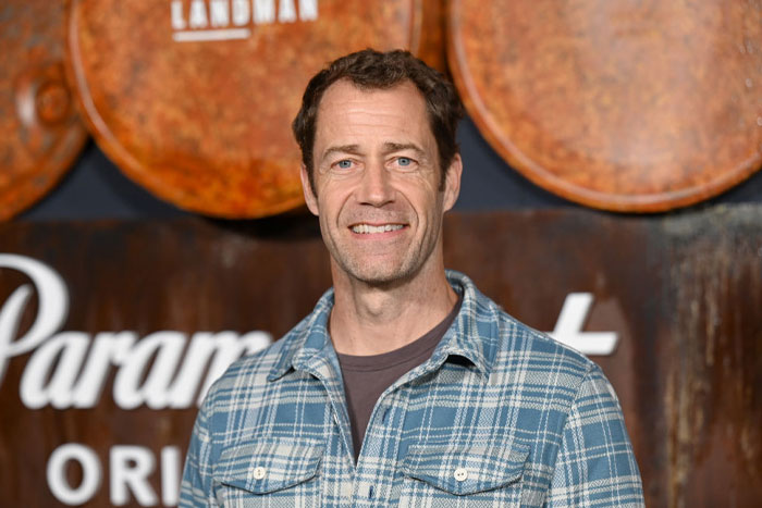 Colin Ferguson smiling at an event, wearing a plaid shirt, representing familiar faces from The Summer I Turned Pretty cast.