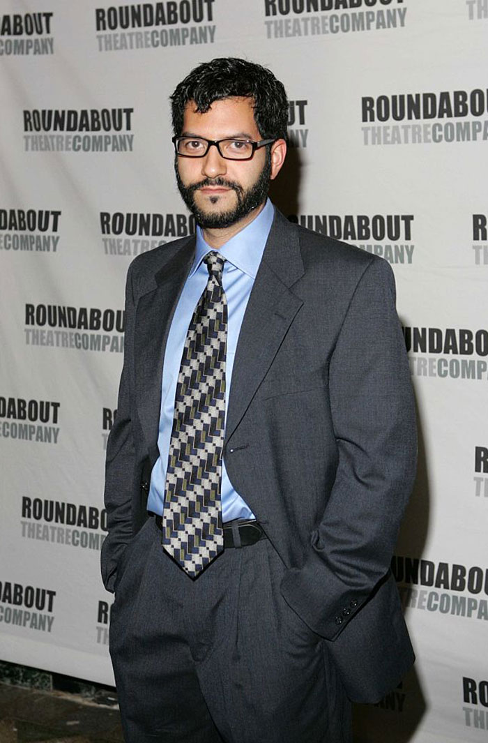 Alfredo Narciso in a suit posing at an event backdrop, related to "The Summer I Turned Pretty" cast of rising stars and familiar faces.