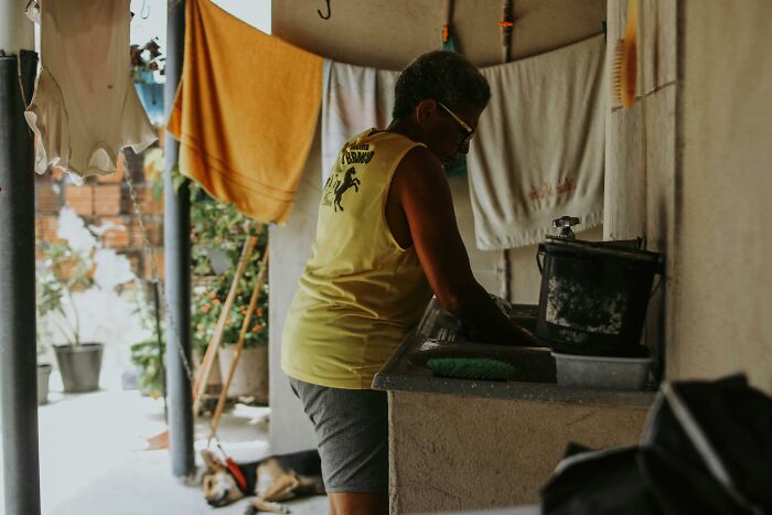 Person doing laundry outdoors, exemplifying clever tips for living cheap without sacrificing comfort.