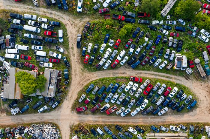 Aerial view of a car junkyard, showcasing clever tips for living cheap by using second-hand vehicles.