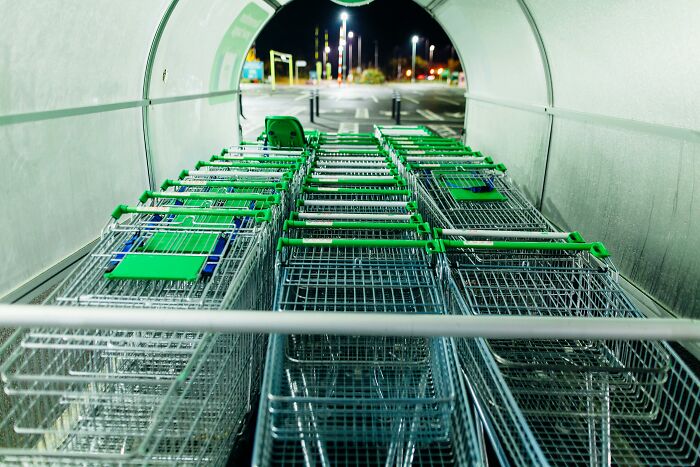 Shopping carts lined up in a parking lot at night, illustrating clever tips for living cheap.