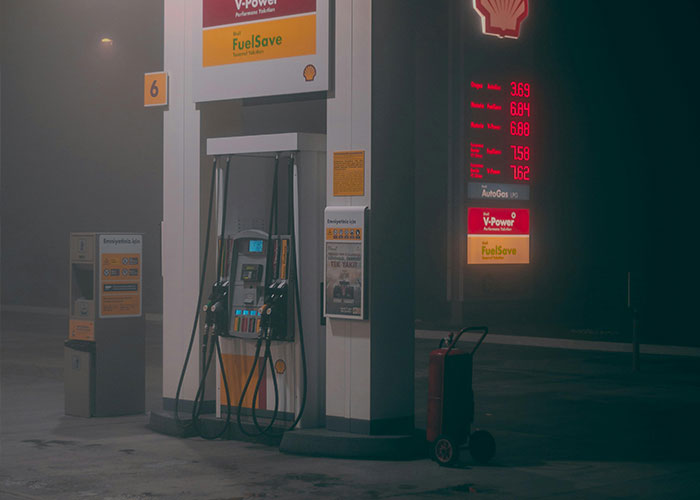 Shell gas station at night, showcasing retro fuel prices; illustrating a life cheat code setting mood.