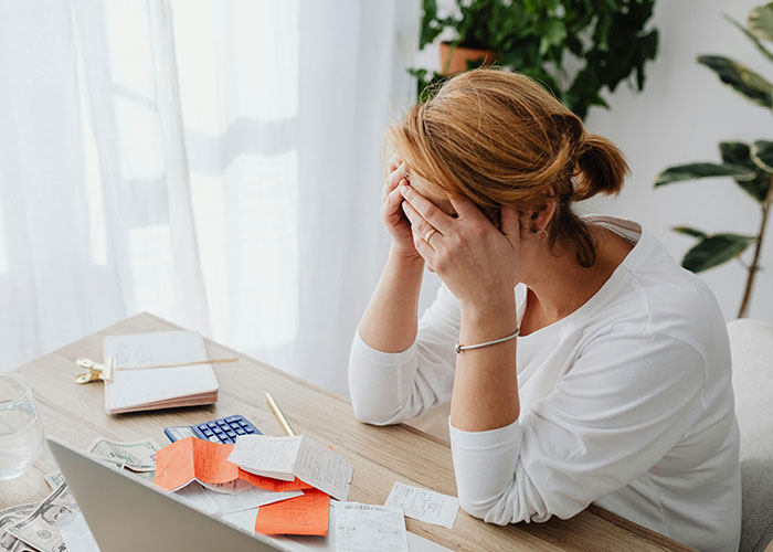 A person stressed over bills at a desk, showcasing a need for life cheat codes that actually work.