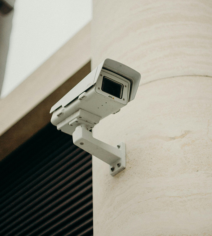 Surveillance camera mounted on a building, representing security concerns in a Chinese-Canadian context.