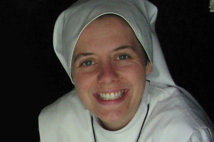 A smiling woman in a nun's habit, symbolizing transformation from actress to nun.