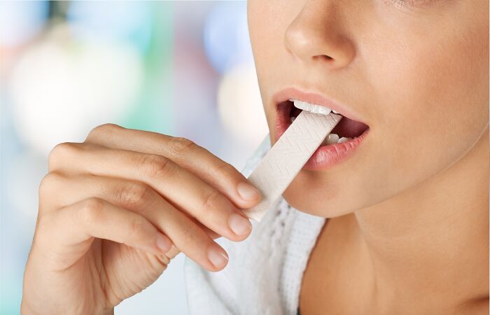 Millennial eating gum illustrates growing habits in adulthood.