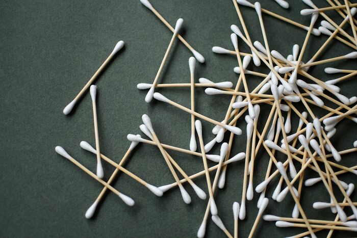 Cotton swabs scattered on a green surface, illustrating everyday items in contrast to expensive items worth spending money.