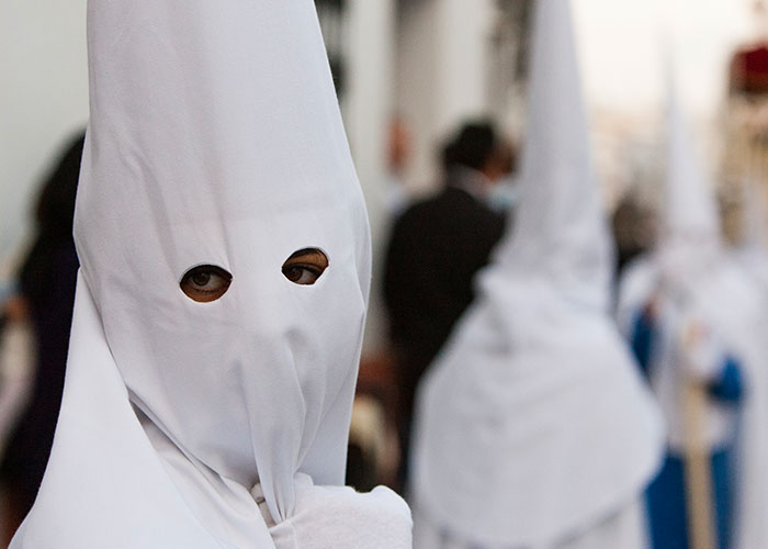 A person wearing a white hooded robe; secrets and mystery implied.