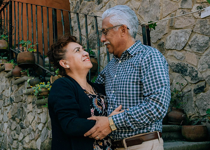 Elderly couple embracing outdoors, showcasing family connection and warmth.