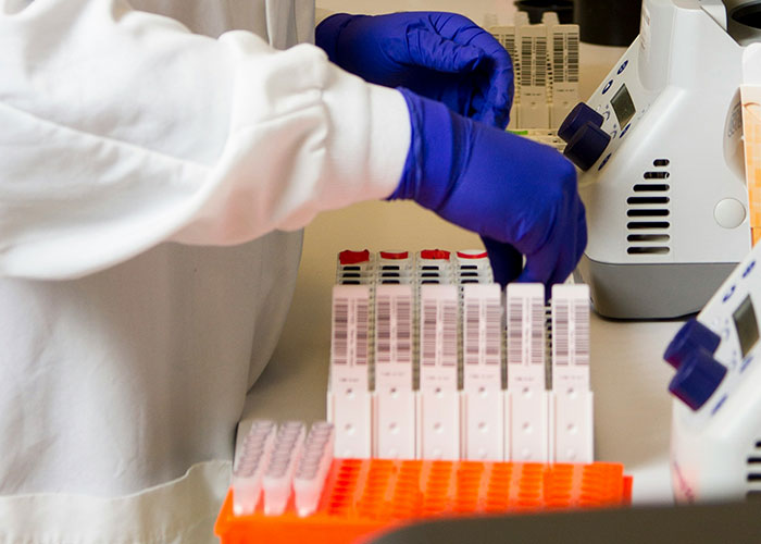 Lab technician in gloves handling medical samples, part of unsettling medical facts exploration.