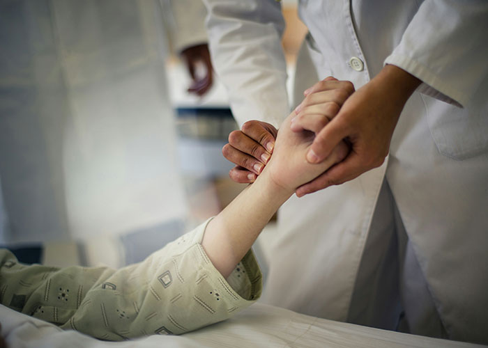 Doctor holding a patient's wrist in a medical setting, illustrating an unsettling medical fact.