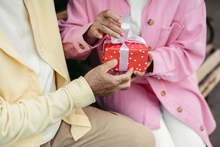 Couple exchanging an adorable polka dot gift, symbolizing love and connection.