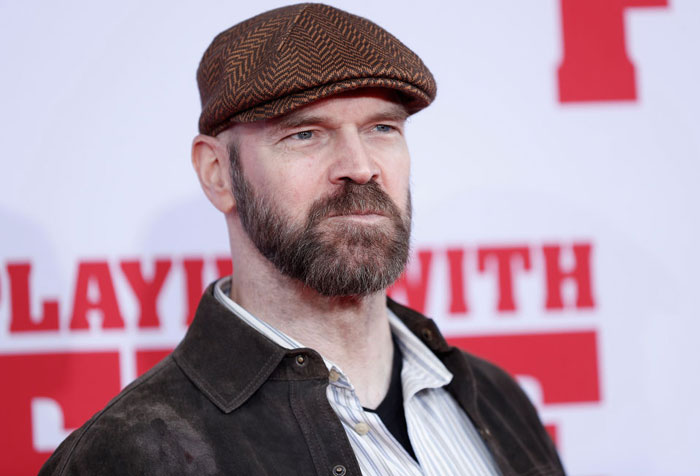 Tyler Mane in a hat and jacket at a movie premiere, linked to the Deadpool cast.